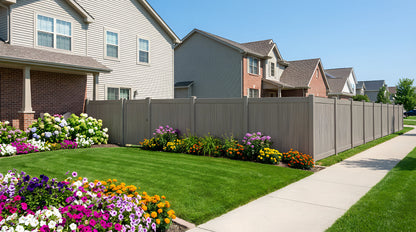 A suburban neighborhood with gray PVC privacy fence panels and exterior gardens.