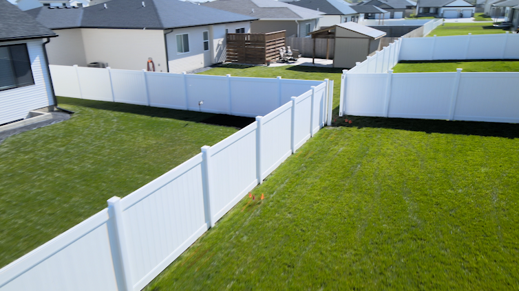 A Nebraska residential neighborhood with adjoining vinyl fences.